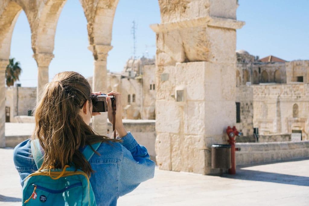 Une femme photographie des ruines.